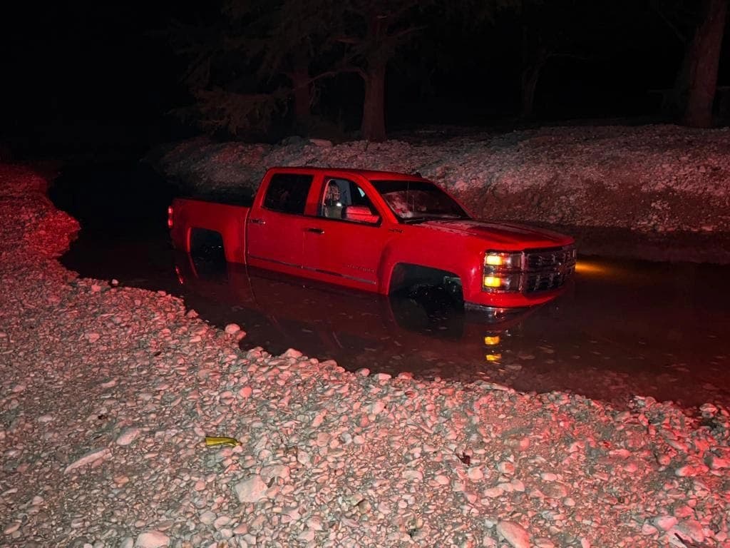 Indigo Towing recovering a pickup truck from a flooded creek crossing at night