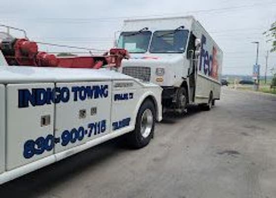 Indigo wrecker hooking up a box truck